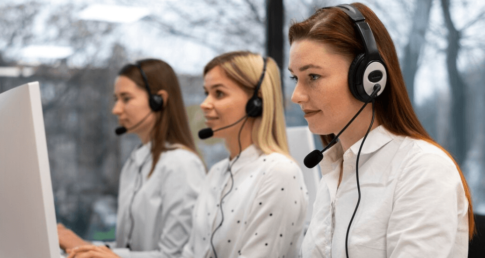 mulheres com headfones sentadas em frente al computador